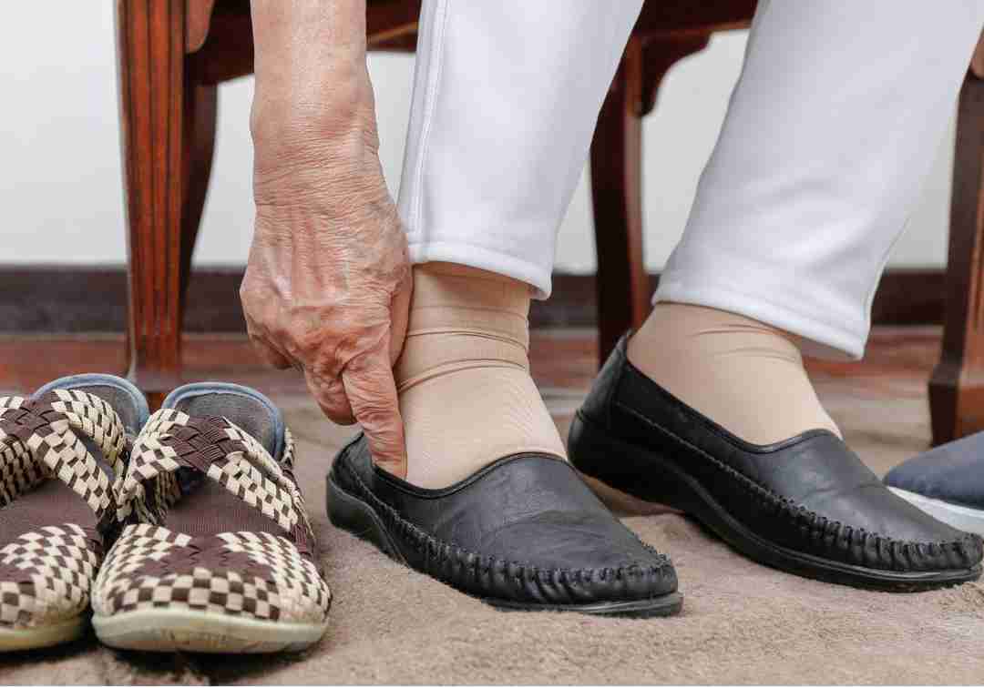 An older person putting on their shoes, symbolising independence and personal care.