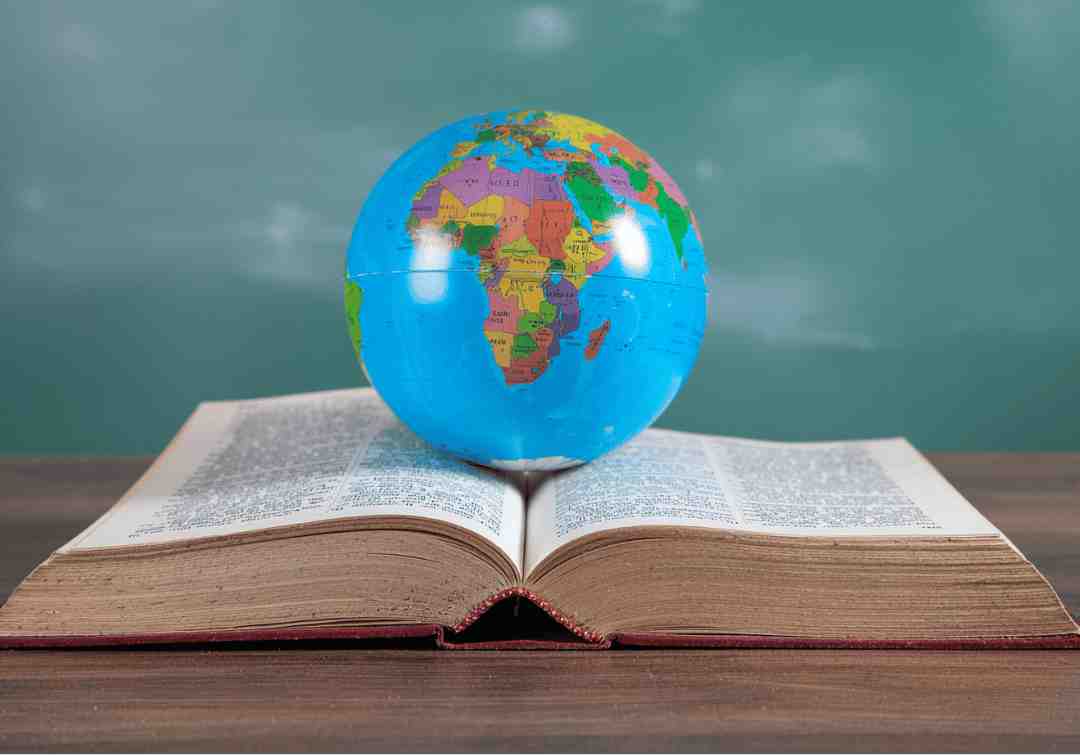 An open hardcover book with a globe resting on its pages, symbolising the power of stories to connect people worldwide.